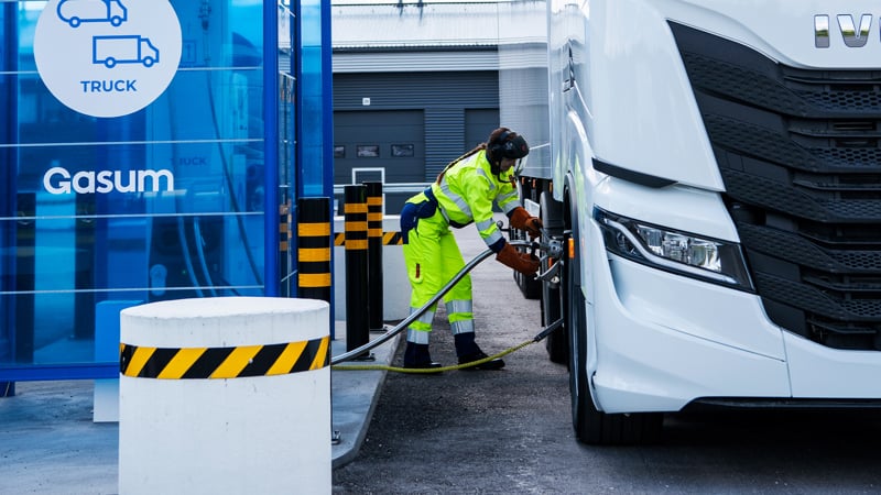 Henkilö työvaatteissa tankkaamassa LNG:tä kaasukäyttöiseen rekkaan. 